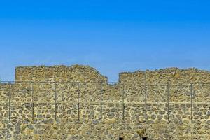 imagen del antiguo muro de piedra en las ruinas del castillo de muenzenberg en contraste con el cielo azul foto