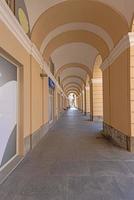 Picture along an old archway with pastel-coloured stone columns photo