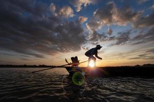 los pescadores en la sombra conducen botes motorizados con redes para pescar en los ríos de tailandia, pesca en asia. foto