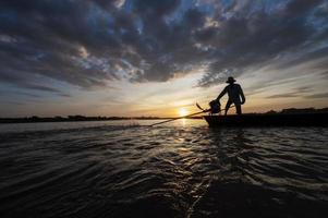 los pescadores en la sombra conducen botes motorizados con redes para pescar en los ríos de tailandia, pesca en asia. foto