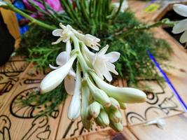 Polianthes tuberosa flower crown against a wooden table background photo