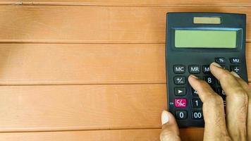 businessman hand working with calculator on wooden table photo