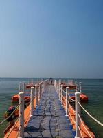 Floating piers along shore are place for tourists walk. Mooring boat plastic pontoon that floats in sea water. Blue sea view blue background look wave calm landscape viewpoint summer Nature tropical photo