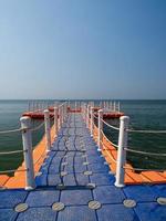 Floating piers along shore are place for tourists walk. Mooring boat plastic pontoon that floats in sea water. Blue sea view blue background look wave calm landscape viewpoint summer Nature tropical