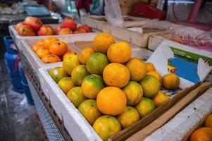 cerrar grupo de naranja en el puesto en el mercado de la calle callejón viejo en tailandia. foto