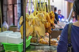 pollo hervido y pato al vapor colgando en el puesto del mercado en el antiguo callejón del centro del mercado de yaowarat chinatown bangkok city tailandia. foto