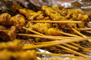 cierre la brocheta de satay de cerdo con bambú seco en el foy. Esta receta tailandesa de satay de cerdo es fácil de preparar y se puede comer como aperitivo, refrigerio o plato principal. foto