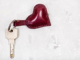 door key with heart shape keychain on concrete photo