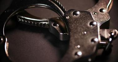Close up of metal handcuffs on dark background video