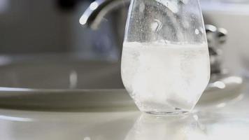 Effervescent Cold Tablets Dropping Into a Water Glass Near Bathroom Sink video