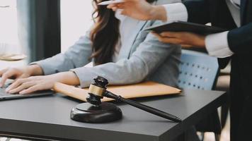 Justice and law concept.Male judge in a courtroom with the gavel, working with, computer and docking keyboard, eyeglasses, on table in morning light video