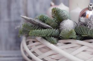Winter or Christmas centerpiece wreath with candles, new year toys, spice and fir branches on gray wooden background photo