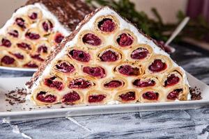 A traditional Moldavian dessert or cake consisting of pancakes with cherry, milk creme and chocolate creme also called Cosma lui Guguta. photo