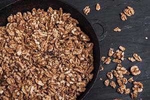 Walnut background. Peeled walnuts on a iron plate on black. walnuts a real super food full of vitamins and vegetable fats photo