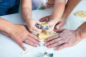 Family cooking homemade cakes. Moms and children hands holding cookie cutters. Family Cooking flat lay. Sweet home. Happiness concept. photo