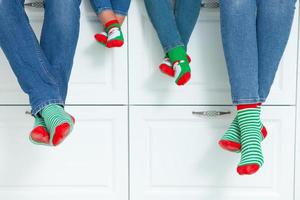 el concepto de una familia feliz vestida con medias navideñas en la cocina foto