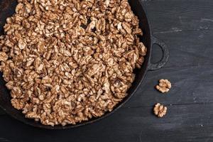 Walnut background. Peeled walnuts on a iron plate on black. walnuts a real super food full of vitamins and vegetable fats photo