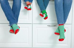 el concepto de una familia feliz vestida con medias navideñas en la cocina foto