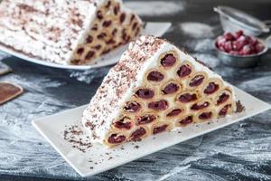 un postre o pastel moldavo tradicional que consiste en panqueques con cereza, crema de leche y crema de chocolate también llamado cosma lui guguta. foto