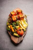 Paneer Sizzler is an Indian version with cottage cheese, salad served sizzling on hot stone dish. photo