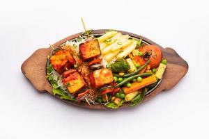 Paneer Sizzler is an Indian version with cottage cheese, salad served sizzling on hot stone dish. photo