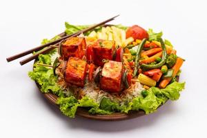 Paneer Sizzler is an Indian version with cottage cheese, salad served sizzling on hot stone dish. photo