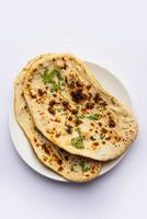 tandoori naan, tandoori roti indio o pan plano servido en un plato, aislado foto