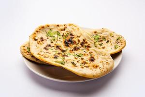 tandoori naan, tandoori roti indio o pan plano servido en un plato, aislado foto