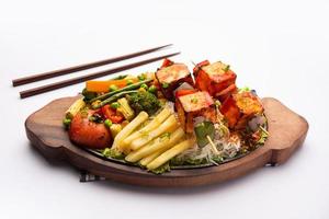 Paneer Sizzler is an Indian version with cottage cheese, salad served sizzling on hot stone dish. photo