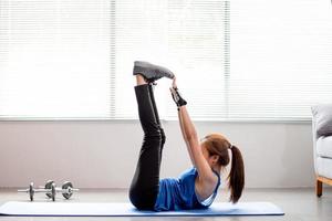 las mujeres asiáticas hacen ejercicio para fortalecer los músculos abdominales en casa. foto