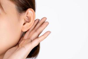 Female with hearing problem on white background. Close up. photo