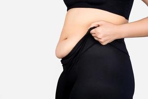 Overweight woman wearing black pants and fat on hips and stomach isolated on white background photo