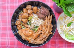 fideos de pollo con patas de pollo, muslos de pollo, articulaciones de pollo y verduras de acompañamiento, brotes de soja, calabaza amarga en rodajas. foto