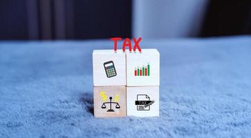 Concept of taxes paid by individuals and corporations such as VAT, income tax and property tax Data analysis, paperwork,Financial research,TAX on block cubes. photo