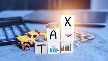 Concept of taxes for car on block cubes paid by individuals and corporations such as VAT, income tax and property tax Data analysis, paperwork,Financial research. photo