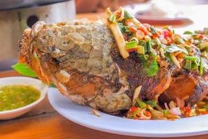 Whole fried snakehead fish, seasoned with chopped mango, lemongrass, chili, spring onions photo