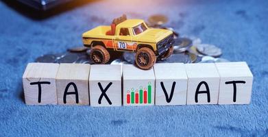 Concept of taxes for car on block cubes paid by individuals and corporations such as VAT, income tax and property tax Data analysis, paperwork,Financial research.