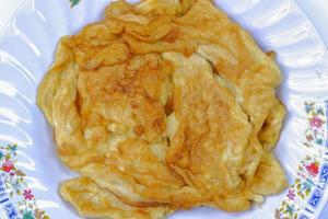 top view fried omelet in white plate on white background photo