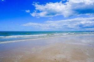 beach by the sea The sea waves crashing against the shore and the beautiful. photo