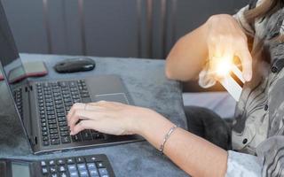 Woman using credit card filling in billing information in purchase of laptop computer in ecommerce store. Concept online payment. Internet accessible money transactions photo