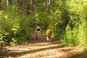 Adorable girl walking with dog photo