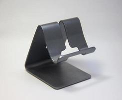 Small metal steel smartphone mobile phone desk stand display photo isolated on plain background.