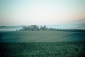 vista de niebla matutina en casa de campo en toscana, italia foto