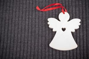 Craft Wooden Angel on Grey Knitted Background photo