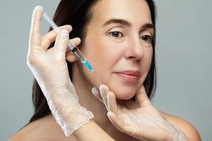 Middle aged woman receiving facial injection for skin rejuvenation photo