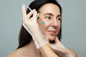 Middle aged woman receiving facial injection for skin rejuvenation photo