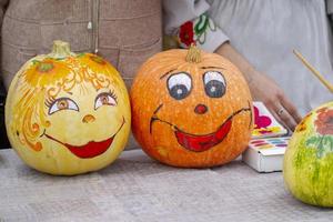 calabazas creativamente decoradas para halloween. una cara amable con una sonrisa pintada en una calabaza. foto