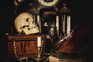 Close-up still life, Dutch painting of the 17th century. On the table on a black background are flowers, a skull, a clock, a violin, keys. Things that tell about a person's life. photo