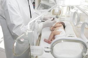 un bebé recién nacido yace en cajas en el hospital. un niño en una incubadora. unidad de cuidados intensivos neonatales y prematuros foto