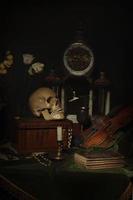Bodegón de primer plano, pintura holandesa del siglo XVII. sobre la mesa sobre un fondo negro hay flores, una calavera, un reloj, un violín, llaves. cosas que hablan de la vida de una persona. foto